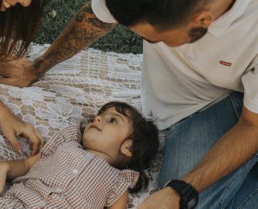 Relaxing family picnic with parents and child outdoors on a summer day.