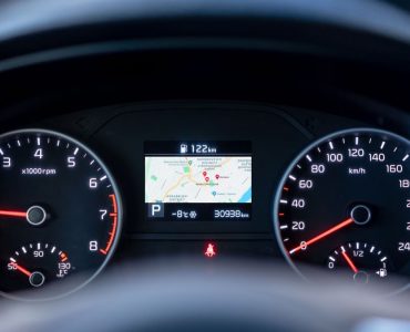 Close-up of a car dashboard showing speedometer, tachometer, and GPS display.