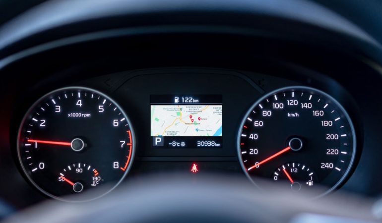 Close-up of a car dashboard showing speedometer, tachometer, and GPS display.